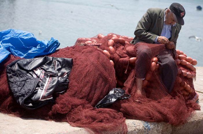 File:Fisherman mending net.jpg