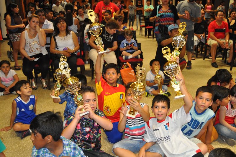 File:Several children holding futbal trophies.jpg