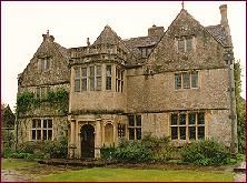 Honey coloured building with prominent porch and triangular fronting to the roof.