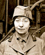 A white woman wearing glasses and a military-style uniform with cap