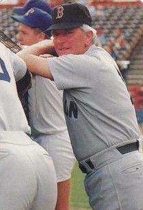 A man in a gray baseball uniform and black cap