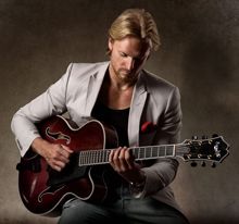 Posed photo of Öberg looking down at his guitar