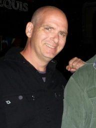 An image of Jason D. Anderson. He has his hand pressed against the back of another person who's face is not in frame.