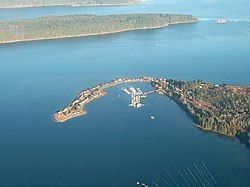 Aerial view of Deep Bay Marina with Baynes Sound, Denman Island (Chrome Island Light off its tip) and Hornby Island in the background.