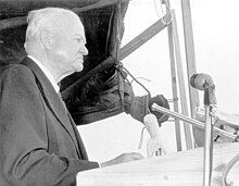 A man (former President Herbert Hoover), speaking behind a podium