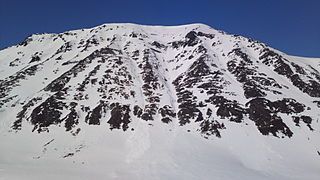 Storbukttind (literally, 'Big Bay Peak'; 1,054 meters or 3,458 feet) stands just west of route E6.