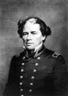 Photograph of a man, seated, in a double-breasted naval uniform