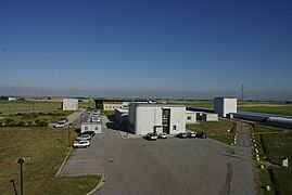 Above-ground view of the site, with parked cars for scale