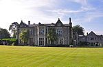 a grass lawn in front of a large house