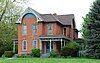 Picture of the house, a two-storey brick building with decorative gables