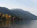 A lake as it encounters foothills covered in trees