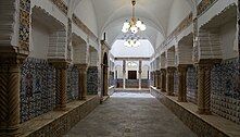 Hallway lined by pillars decorated with patterned tiles