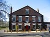 A brick Georgian-style house with five bays, two storeys and an attic