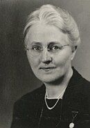 Portrait of a light haired woman with round glasses