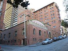 A view of the Chinatown YWCA building at the corner of Joice and Clay in San Francisco's Chinatown. The building is a large brick structure.