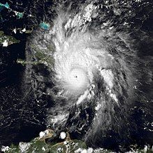 Satellite image of a mature hurricane. The storm features a small, but prominent eye and the whole system covers most of the eastern Caribbean Sea. Haiti can be seen along the edge of a feeder band and eastern Cuba is also visible on the left side of the image.