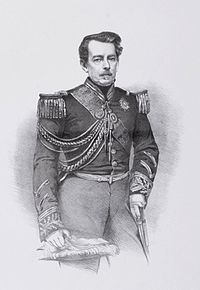 Lithograph of a drawing featuring a three-quarters length portrait of a middle-aged man with moustache wearing a military tunic with embroidered cuffs and decorated with epaulettes, lanyards, a sash of office and several medals and orders at his neck, and holding a feathered bicorne hat in his right hand