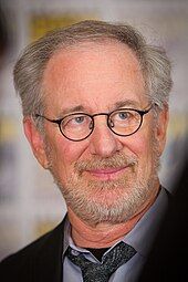 A man with glasses and gray hair in professional attire.