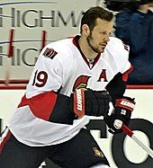 bearded man in hockey equipment