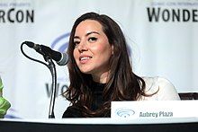 A face shot of Aubrey Plaza speaking into a microphone