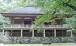 Wooden building. In front of the entrance there is an open veranda consturcted on poles.