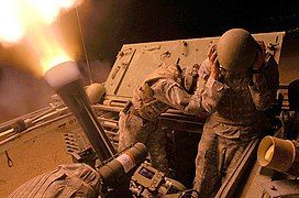 A close-up of the Cardom 120 mm recoil mortar system firing at night