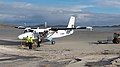 Twin Otter at Barra airport, ground crew preparing for takeoff