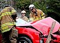 Raleigh firefighters work on dismantling a car.