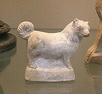 A terracotta figure of a small, fluffy dog, made in Italy in the 1st century BC – 1st AD