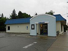 Maple Plain Library, a one-story white building with a blue sloped roof and a teal, arched entryway.