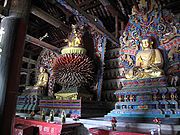 Ming dynasty statues of Vairocana (center), flanked on the far left by Amitabha and on the right by Bhaisajyaguru. Projecting tongues from Vairocana's throne are petals that symbolize his radiance in infinite directions.