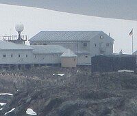 A small wooden structure next to several grey buildings