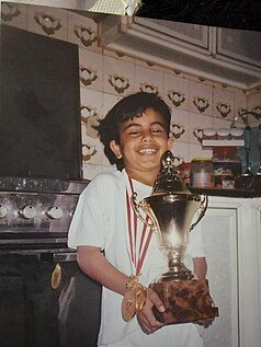 A picture of young Hashem with a tournament cup and medals around his neck.