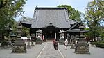 A wooden building with a large irregularly shaped roof.