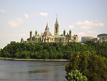 A building in neo-Gothic style, with a central clocktower rising from a block stretching east and west