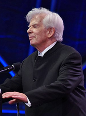 elderly man with full head of white hair in formal attire