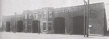 One storey brick building with large doors and rail tracks leading to them