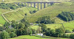 A steep valley with a railway viaduct of the far side