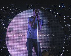 Kid Cudi performs in front of a moon in 2009.