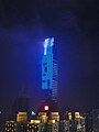 The KK100 building at night, with the top visible through low clouds.