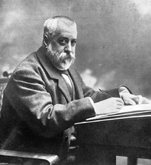 Black and white photograph of Menéndez y Palayo writing at a desk