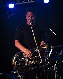 a musician playing a modified tuba with a periscope like mouthpiece