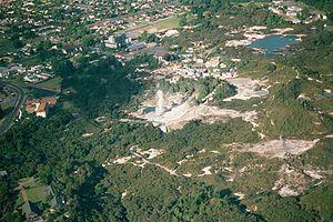 Aerial view of Whakarewarewa; Pōhutu Geyser is erupting.