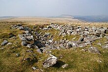 A large oblong depression full of stones