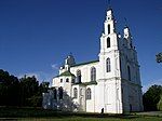 White church with green roof and two bell towers, side view