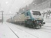 Two class E412 locomotives pull a train during a snowstorm