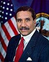 man in business suit, American flag in background