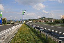 A view of the motorway next to a rest area, with a rest area sign in the background