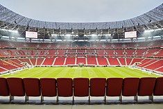 Photograph of a modern football stadium's interior; the stands are full of spectators