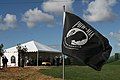 Ceremony attendees gather before the start of a burial while the iconic Prisoner of War/Missing in Action flag waves over the grounds.